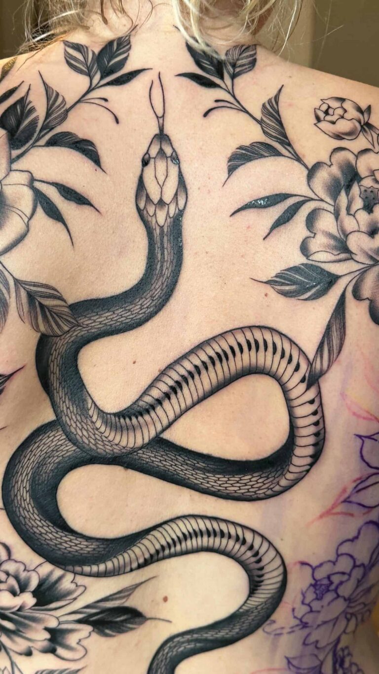 Blackwork tattoo of snake on a blond womans back.