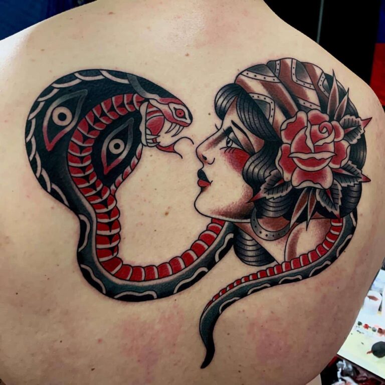 Traditional tattoo of a snake with an open mouth and a girl with a flower in her hair looking at eachother.