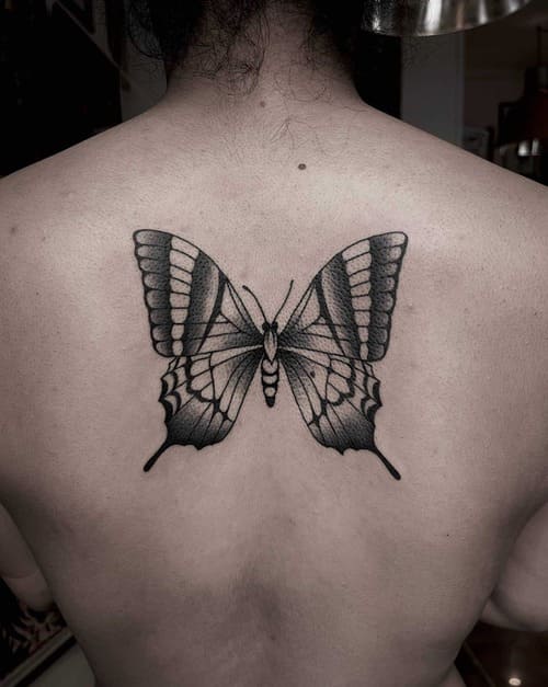 Blackwork tattoo on a back of a butterfly.