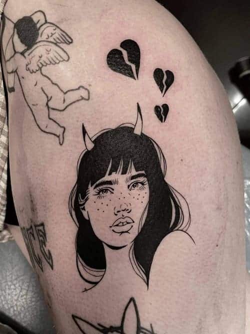 Blackwork tattoo of a girl with freckels and three broken hearts above her head.