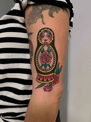 Traditional tattoo on a arm of an old woman with flowers under her.