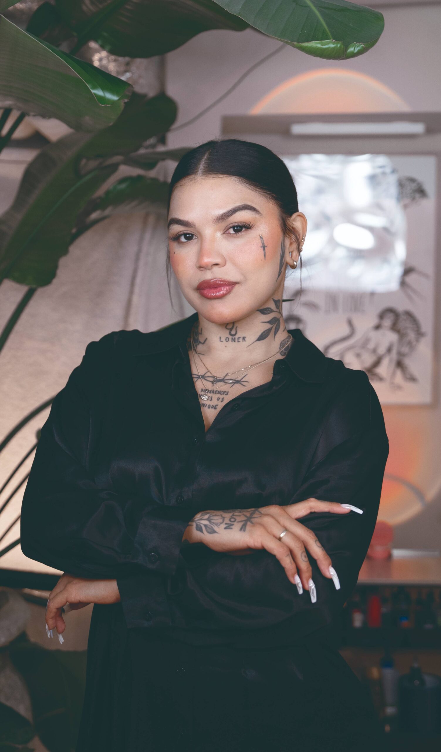 Tattoo artist standing up with her arms crossed inside of a tattoo shop in Stockholm.