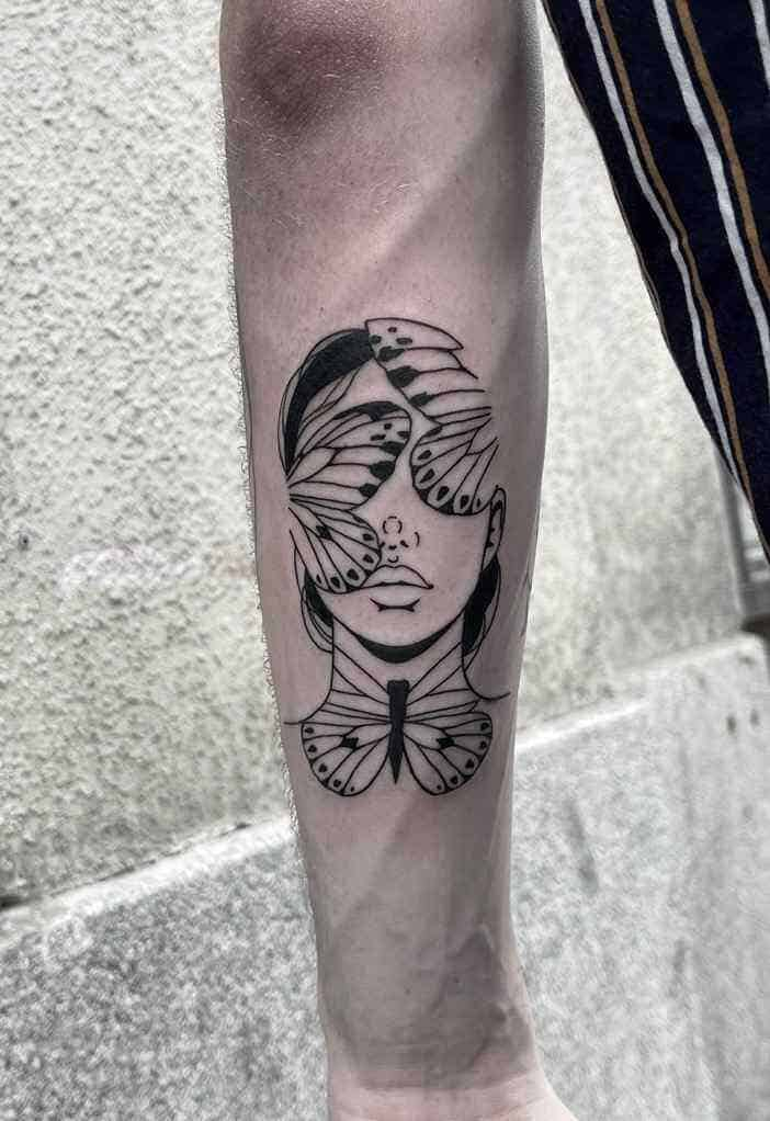 Fine line tattoo of tattoo on a forearm of a womans face with two butterfly wings covering her eyes and one butterfly covering her neck.