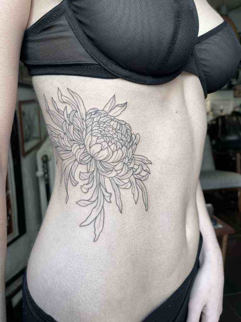 Fine line tattoo of a rose on a stomach.